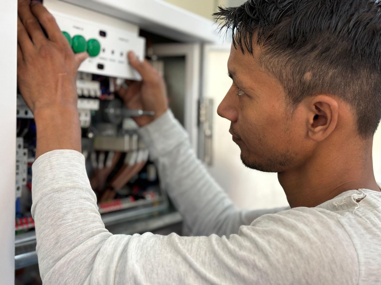 Electrician reviewing an electrical control panel